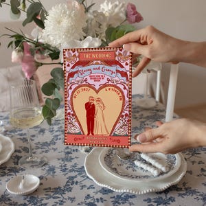 Tunnel of Love inspired vintage circus wedding invitation suite mockup: 5x7 main invitation with bride, groom, swans, and heart-shaped archway design; 4x6 details card; 5x3.5 RSVP card in two variations with QR code option; red diamond harlequin pattern backs with S+G heart monogram; bonus 10.5x2 belly band. Whimsical retro carnival-style editable printable wedding stationery template set by Krist Lunaire Co.