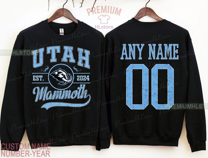 K&ouml;nnte beinhalten: Schwarzes Sweatshirt mit hellblauem Text und Grafiken. Die Vorderseite zeigt "UTAH", "EST. 2024" und "Mammoth" mit einem Logo. Auf der R&uuml;ckseite steht "ANY NAME" &uuml;ber der Nummer "00".
