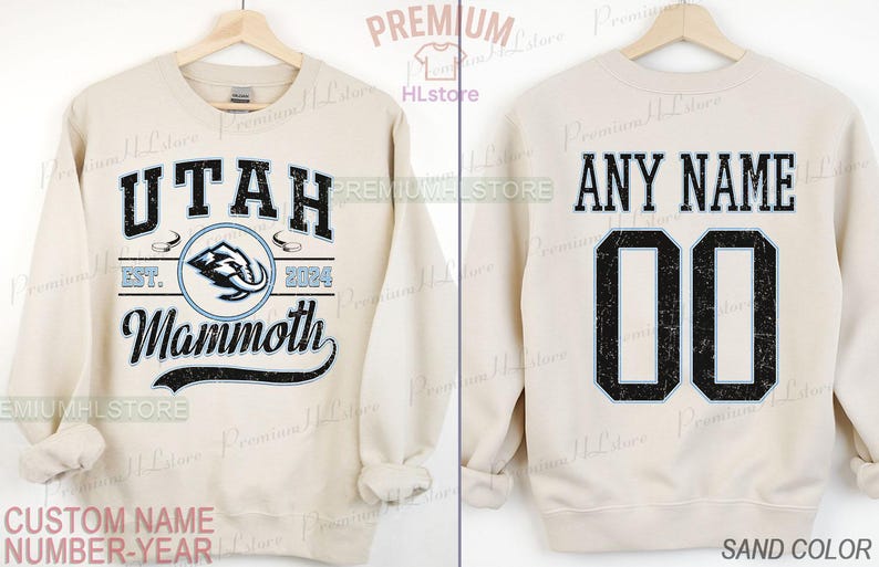 K&ouml;nnte beinhalten: Sandfarbenes Sweatshirt mit dem Text "UTAH Mammoth" in Schwarz und Hellblau sowie einer Mammut-Grafik. Auf der R&uuml;ckseite steht "ANY NAME" &uuml;ber der Nummer "00".