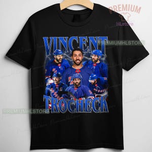 May include: Black t-shirt featuring a graphic of Vincent Trocheck, a hockey player, with the text "VINCENT TROCHECK" in blue. The design includes images of the player in a blue hockey jersey.