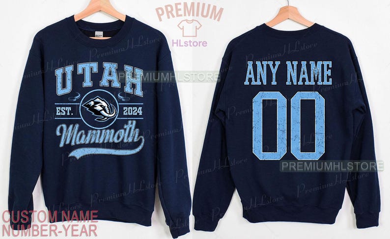 K&ouml;nnte beinhalten: Marineblaues Sweatshirt mit "UTAH" in Hellblau, einem Mammoth-Logo und "EST. 2024". Auf der R&uuml;ckseite stehen "ANY NAME" und die Nummer "00" in Hellblau. Ein individueller Name und eine Nummer k&ouml;nnen hinzugef&uuml;gt werden.