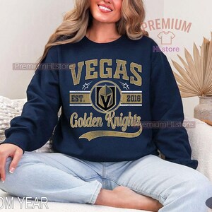 Puede incluir: Sudadera azul marino con la inscripci&oacute;n dorada "VEGAS Golden Knights". El dise&ntilde;o incluye el logotipo del equipo y el a&ntilde;o "2016". La sudadera es de manga larga y cuello redondo.