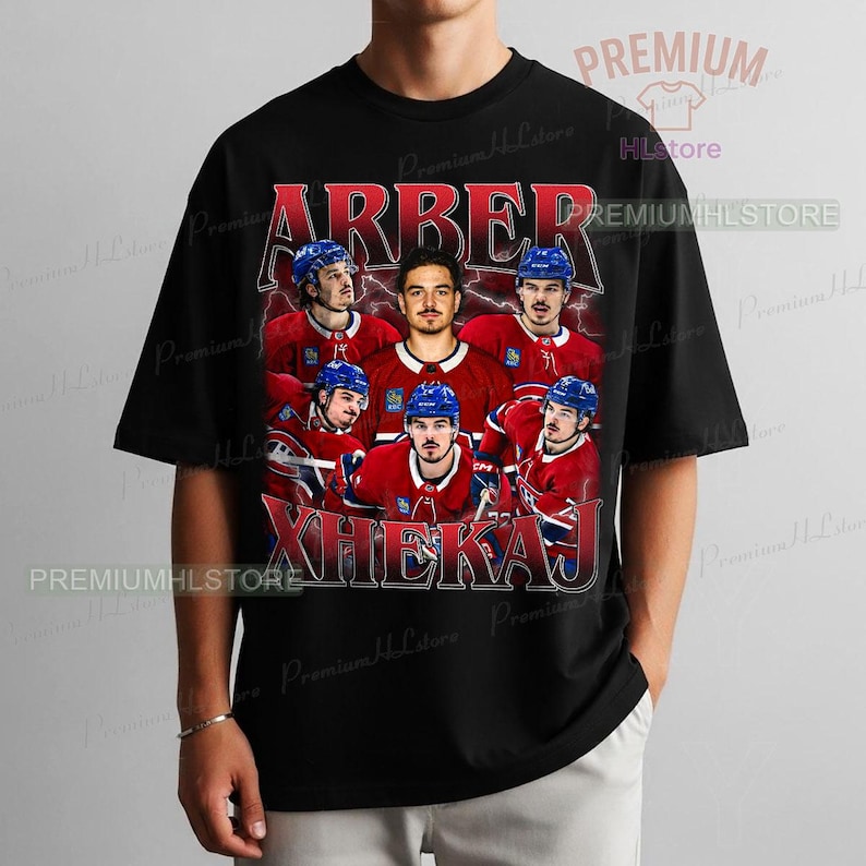 May include: Black t-shirt featuring a vintage-style graphic of a hockey team. The design includes the team's name in red, along with images of the players in their red and blue uniforms. The text "ARBER XHEKAJ" is prominently displayed.