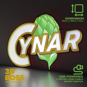 May include: A backlit sign featuring the word "CYNAR" in white letters with a yellow outline, and a green artichoke illustration. The sign is USB powered and measures 45cm x 36cm x 4cm. The text "3D BOSS" and website address are also visible.