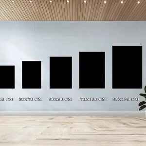 May include: Five black rectangular art prints of varying sizes are displayed on a light gray wall. The sizes are labeled in centimeters: 40x60 cm, 50x70 cm, 60x90 cm, 70x100 cm, and 80x120 cm. A small potted plant sits on the floor.