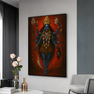 Op de afbeelding: Een ingelijste canvas print van de hindoe-godin Kali, afgebeeld met blauwe huid, meerdere armen en een slinger van schedels. Ze houdt verschillende wapens en een afgehakt hoofd vast tegen een rode achtergrond. Het kunstwerk wordt aan een muur getoond.
