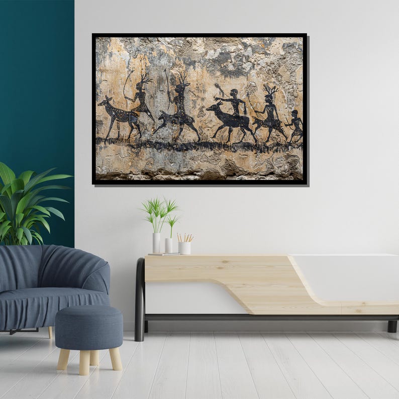 Pu&ograve; includere: Un'opera d'arte incorniciata raffigurante antiche pitture rupestri. Le sagome nere mostrano figure con animali simili a cervi, su uno sfondo strutturato beige e grigio. L'opera &egrave; esposta su una parete bianca.