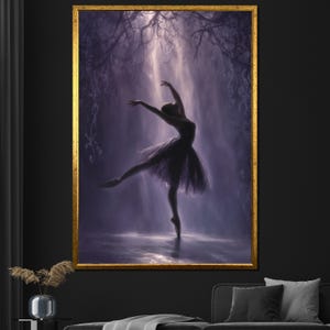 Op de afbeelding: Een ingelijst kunstwerk toont een ballerina in een sierlijke pose, en pointe, met uitgestrekte armen. De danseres is geëffend tegen een achtergrond van zacht, etherisch licht en een donkere, gestructureerde achtergrond. Het frame is goud.