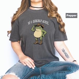 May include: Dark grey t-shirt with a cartoon frog in a cowboy hat and boots. The text "IF I SHENAN ONCE..." is above the frog. The shirt has a relaxed fit.
