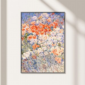May include: Framed floral art print featuring a field of colorful flowers. The artwork showcases a vibrant mix of red, white, and peach-colored blooms set against a backdrop of blue and green foliage. The painting is enclosed in a dark gray frame.