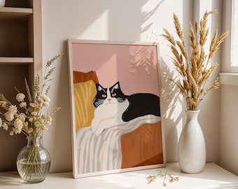 以下が含まれることがあります： ピンクの部屋で、ストライプの毛布の上に横たわる白黒の猫のイラストが額装されています。猫は黄色い目をしており、直接見ています。