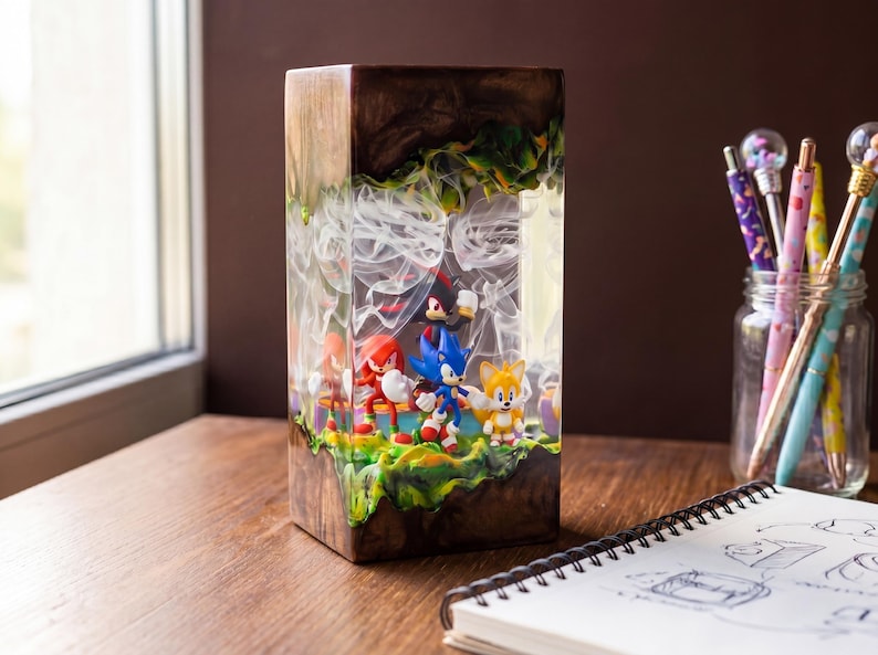 May include: A rectangular resin art piece featuring Sonic the Hedgehog characters. The artwork has a wooden base and a clear resin top with a smoky effect. The characters are set on a green and yellow landscape.