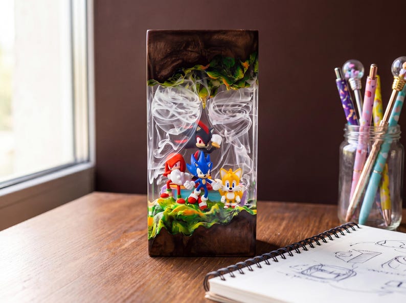 May include: A rectangular resin art piece featuring Sonic the Hedgehog characters. The artwork showcases Sonic, Tails, Knuckles, and Shadow figures set against a backdrop of green, yellow, and brown terrain, with white wisps. The piece is displayed on a wooden surface.