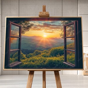 May include: A framed artwork on an easel depicts a scenic landscape viewed through an open window. The artwork showcases a vibrant sunset over rolling hills and lush greenery, with the window frame in dark brown.