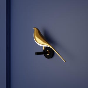 May include: A gold bird sculpture mounted on a black wall with a black metal arm.