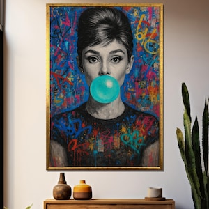 Op de afbeelding: Een ingelijst portret van een vrouw met een turquoise kauwgomballenbel. De achtergrond is een levendige mix van graffiti-kunst in blauw, rood en geel. De lijst is goudkleurig.