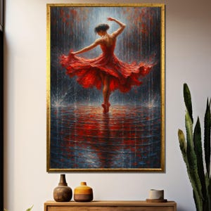 May include: A framed painting depicts a ballerina in a red dress dancing in the rain. The artwork features a gold frame and is displayed on a white wall above a wooden cabinet. The painting's color palette includes shades of red, blue, and gold.