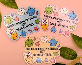 May include: Three die-cut stickers featuring cartoon apples with faces, stars, and speech bubbles. Each sticker displays the text BUILD COMMUNITY CENTRES NOT DATA CENTRES and an orange apple holding a sign with a crossed-out AI symbol.