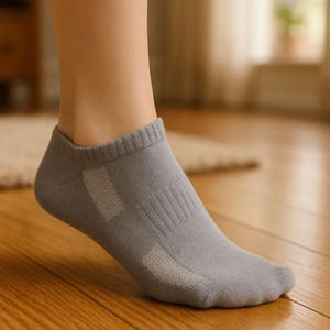 May include: Gray ankle socks with a white mesh panel on the side. The socks are made of a soft, breathable material and are perfect for everyday wear.