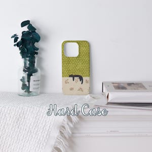 May include: A hard case phone cover with a green polka dot pattern on top and a floral design on the bottom. A black cat is sleeping on the floral section. The words "Hard Case" are written in a script font.
