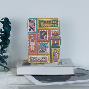 May include: A colorful phone case with a repeating pattern of images from the animated film 'My Neighbor Totoro'. The case features characters like Totoro, the Catbus, and No Face.