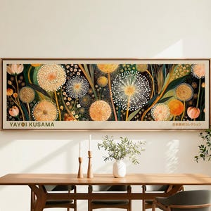 May include: A rectangular framed wall art piece featuring a dark background with numerous spherical dandelion-like flowers in shades of orange, yellow, and white. The text YAYOI KUSAMA and Japanese characters are printed on the bottom border.
