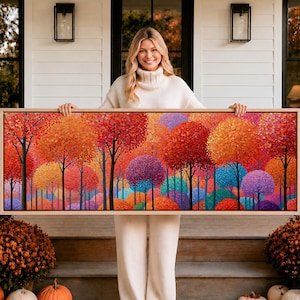 May include: A rectangular landscape painting in a light wood frame featuring a dense forest of stylised trees with rounded canopies in vibrant shades of red, orange, yellow, purple, and blue, showcasing a thick, textured impasto paint application.
