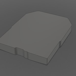 May include: A gray, rectangular object with a beveled top and a recessed section on one side. The object has a solid, geometric design and appears to be made of a matte material. The overall shape is reminiscent of a storage container or a small box.