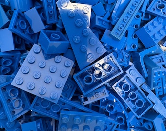 May include: A close-up shot of a pile of blue LEGO bricks of various shapes and sizes. The bricks are scattered, with some partially overlapping. The LEGO logo is visible on several of the bricks. The color is a vibrant, solid blue.