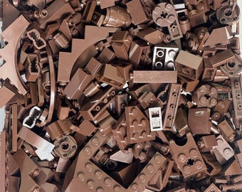 May include: A collection of various brown Lego bricks, including rectangular, angled, and curved pieces. The image shows a variety of shapes and sizes, suitable for building and construction projects. The pieces are in a pile, ready for use.