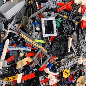 May include: A large collection of colorful Lego pieces, including gears, rods, and blocks. The pieces are in various colors, including red, blue, green, yellow, and black.