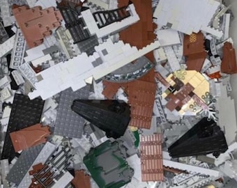 May include: A jumbled assortment of plastic building blocks in various colors, including gray, brown, black, and green. The blocks are of different shapes and sizes, suggesting a construction toy set.