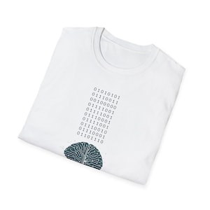 May include: White t-shirt featuring a binary code design and a stylized brain graphic. The binary code is printed vertically, and the brain graphic is located at the bottom. The design is in shades of blue and gray.
