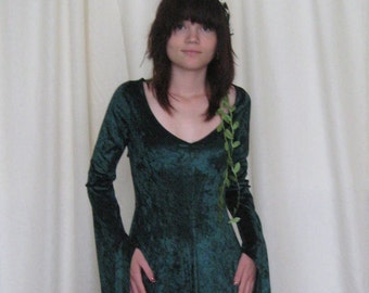 May include: A long, dark teal velvet dress with long, flowing sleeves and a V-neck. The dress has a slight train and is accessorized with a floral crown and a vine detail. The dress is suitable for cosplay or themed events.
