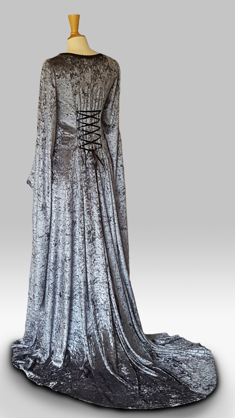 K&ouml;nnte beinhalten: Ein langes, silbergraues Samtkleid mit Schn&uuml;rung im R&uuml;cken und langen &Auml;rmeln. Das Kleid hat einen Schlepp.