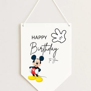 May include: White pennant-shaped wall hanging with the text "HAPPY Birthday To You" and a cartoon image of Mickey Mouse. Mickey is wearing red shorts, yellow shoes, and black gloves. A white gloved hand is also featured.