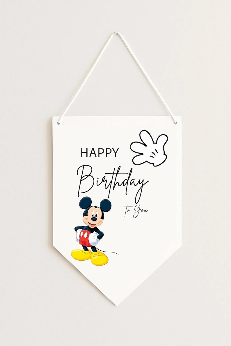 May include: White pennant-shaped wall hanging with the text "HAPPY Birthday To You" and a cartoon image of Mickey Mouse. Mickey is wearing red shorts, yellow shoes, and black gloves. A white gloved hand is also featured.