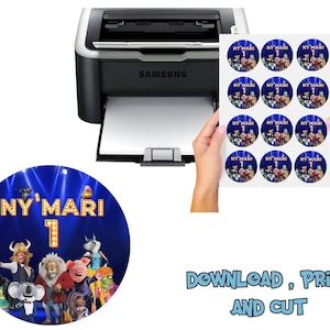 May include: A sheet of round stickers with a blue background and the text "NY'MARI 1" is held in front of a printer. The stickers feature cartoon characters. The image also includes the words "DOWNLOAD, PRINT AND CUT".