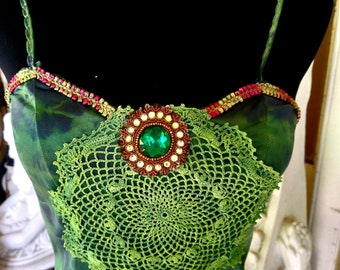 May include: A green crochet lace dress with a large green jewel and gold accents.
