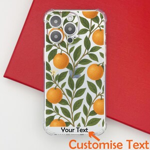 May include: Clear phone case with a white background featuring a pattern of orange fruits and green leaves. The case has the text "Your Text" and "Customise Text" at the bottom. The case is on a red surface.