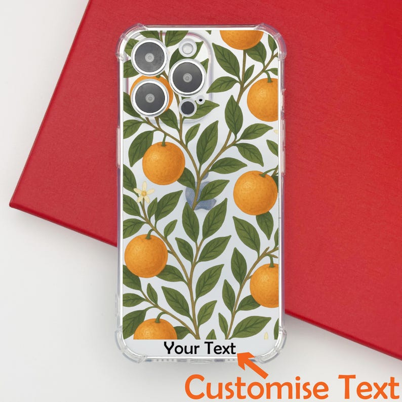 May include: Clear phone case with a white background featuring a pattern of orange fruits and green leaves. The case has the text "Your Text" and "Customise Text" at the bottom. The case is on a red surface.