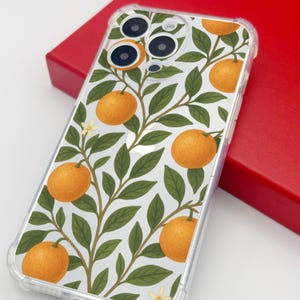 May include: Clear phone case featuring a vibrant orange and green botanical design. The case showcases a pattern of oranges, leaves, and branches against a white background. The case is made of clear plastic and is shown on a red surface.