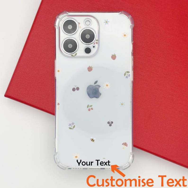 May include: Clear phone case with a floral and fruit pattern, including strawberries, cherries, and daisies. The case has a protective bumper and features the text "Your Text" and "Customise Text".