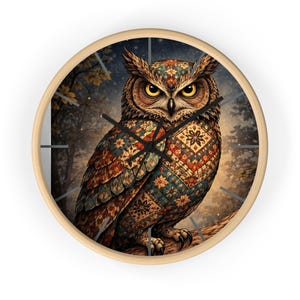 Puede incluir: Un reloj de pared redondo con marco de madera clara. La esfera del reloj presenta una ilustración detallada de un búho con plumas estampadas de colores. El búho está posado en una rama sobre un fondo de bosque.