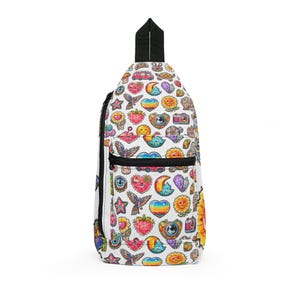 May include: White sling bag covered in colorful, whimsical illustrations. The bag features a black zipper and strap, and is adorned with various designs including hearts, stars, cameras, and rainbows. The bag has a black handle.
