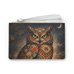Peut inclure: Pochette rectangulaire avec une illustration de hibou détaillée. Le hibou a des yeux jaunes et est orné d'un motif coloré. L'arrière-plan présente un ciel nocturne avec un croissant de lune et des arbres. Une dragonne blanche est attachée.