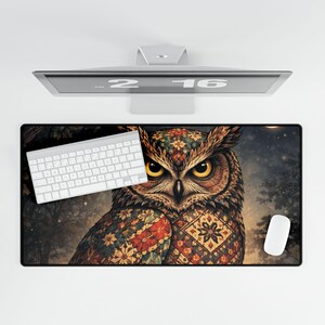 May include: A rectangular desk mat featuring a detailed illustration of an owl with intricate patterns in red, green, and gold. The owl has large yellow eyes. A white keyboard and mouse are on the mat.