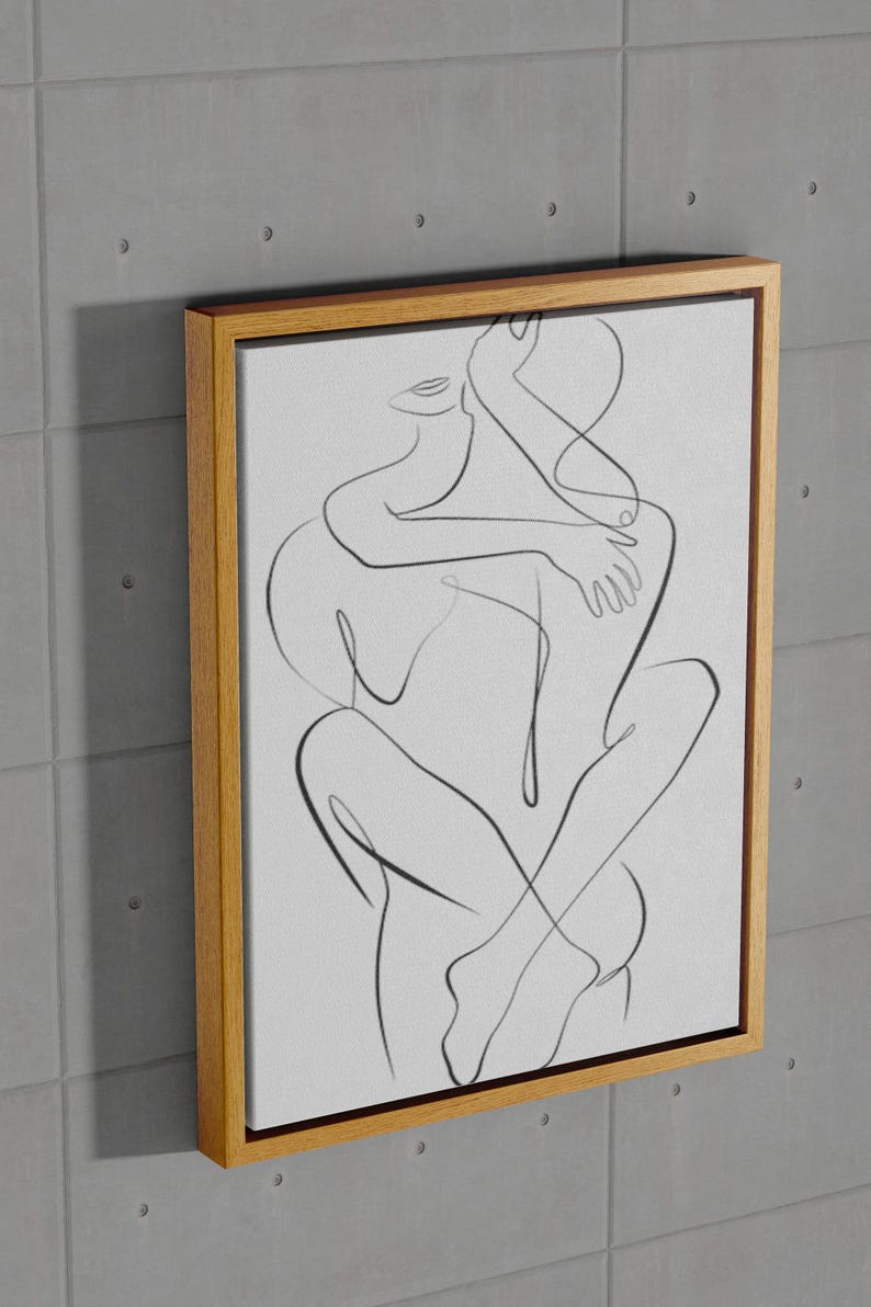 Pu&ograve; includere: Una stampa artistica su tela incorniciata con un disegno a tratto minimalista di due figure che si abbracciano. L'opera &egrave; realizzata con linee nere su sfondo bianco, incorniciata in una cornice di legno naturale. Il pezzo &egrave; montato su una parete grigia strutturata.