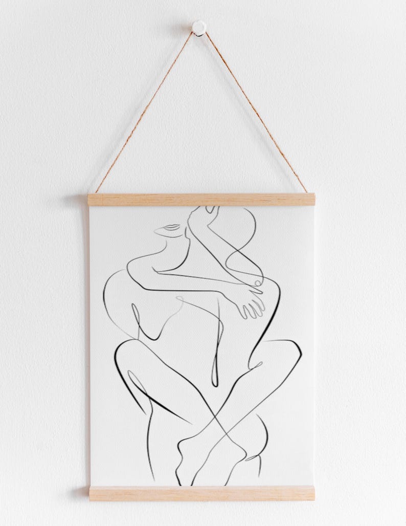 Pu&ograve; includere: Una stampa artistica minimalista a linea nera di due figure che si abbracciano. L'opera d'arte &egrave; esposta su carta bianca, tenuta da barre di legno e sospesa da un cordoncino di spago naturale. Una rappresentazione semplice ed elegante.