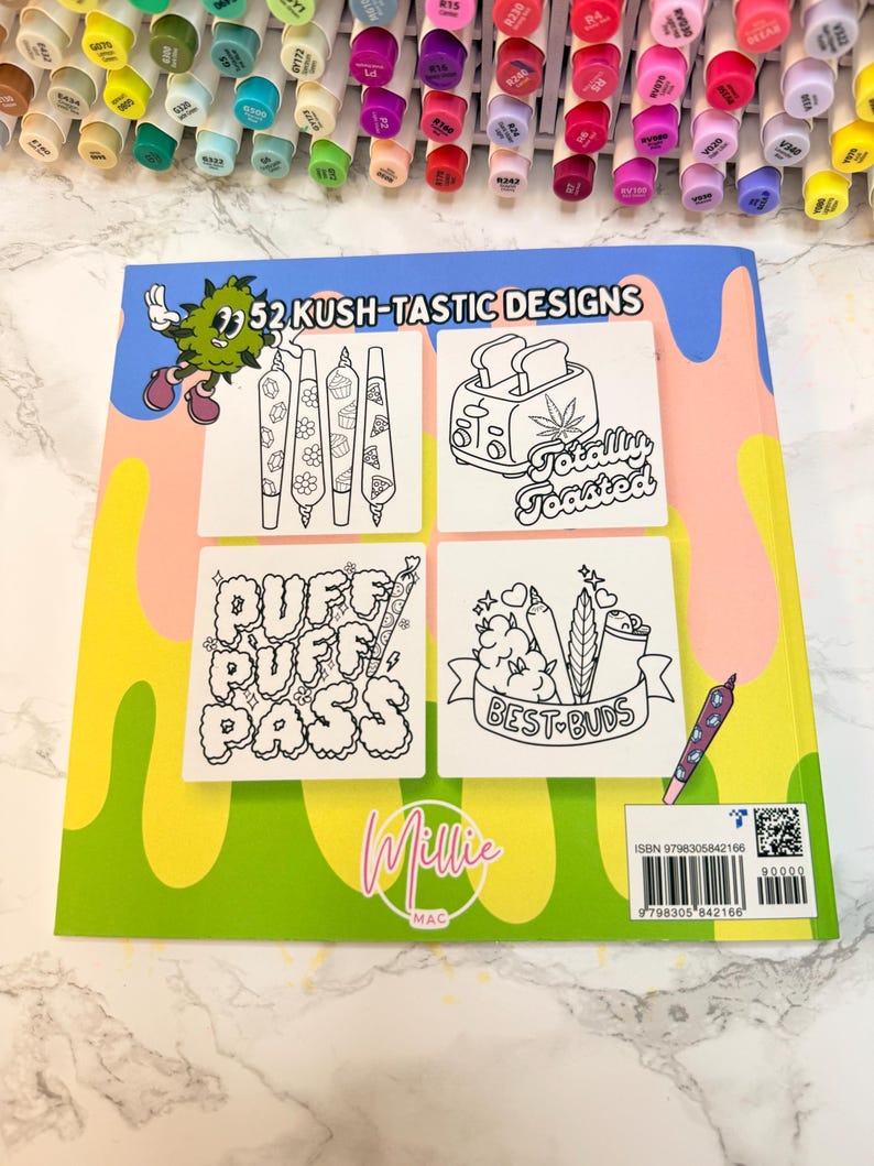 Puede incluir: Un libro para colorear titulado "52 Kush-Tastic Designs" con varias ilustraciones en blanco y negro con temas de cannabis. El libro tiene una portada verde y amarilla con el nombre "Millie Mac" y una variedad de marcadores coloridos en el fondo.